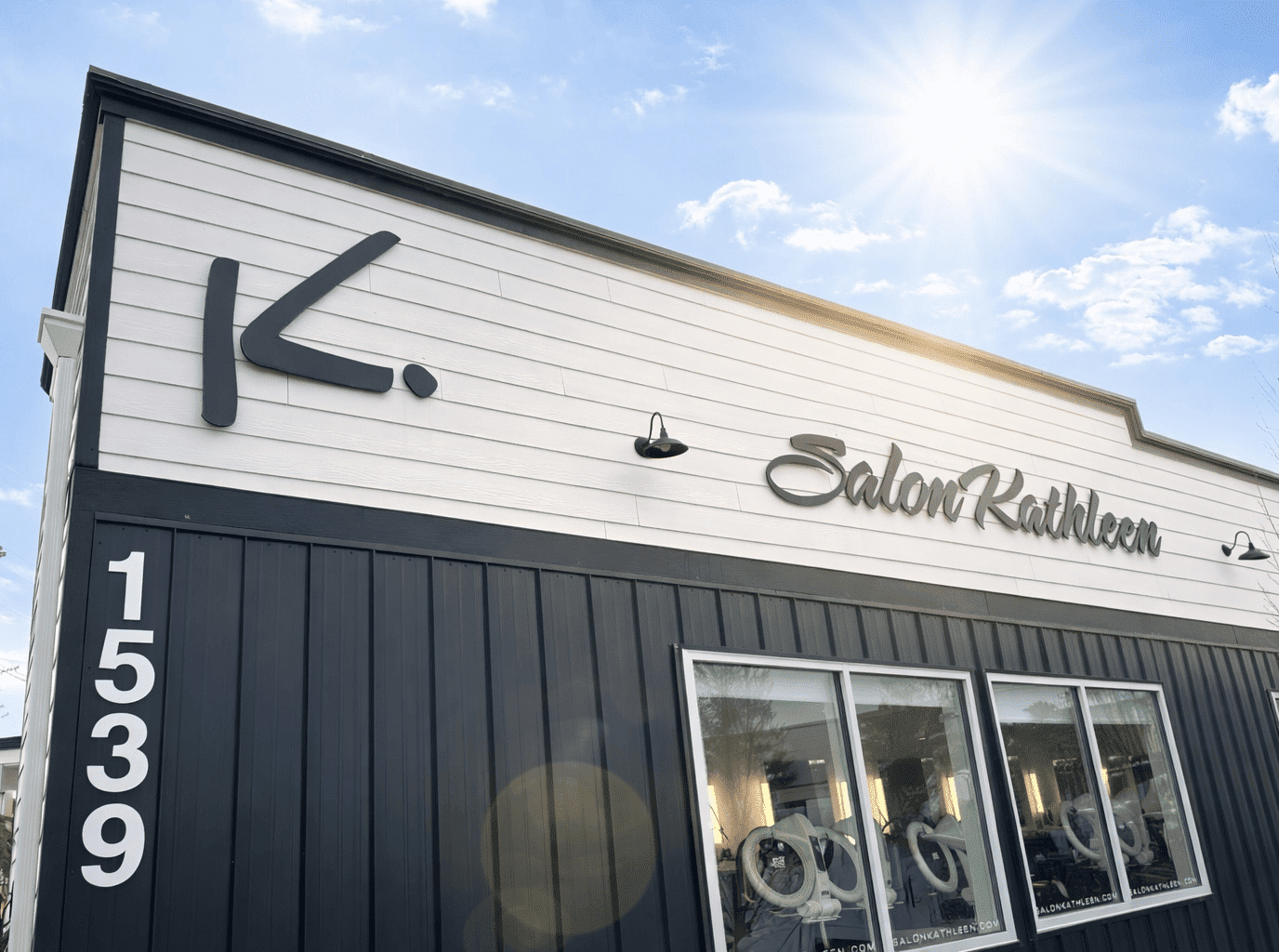 Salon Kathleen exterior with modern design, blue sky, and sunshine.