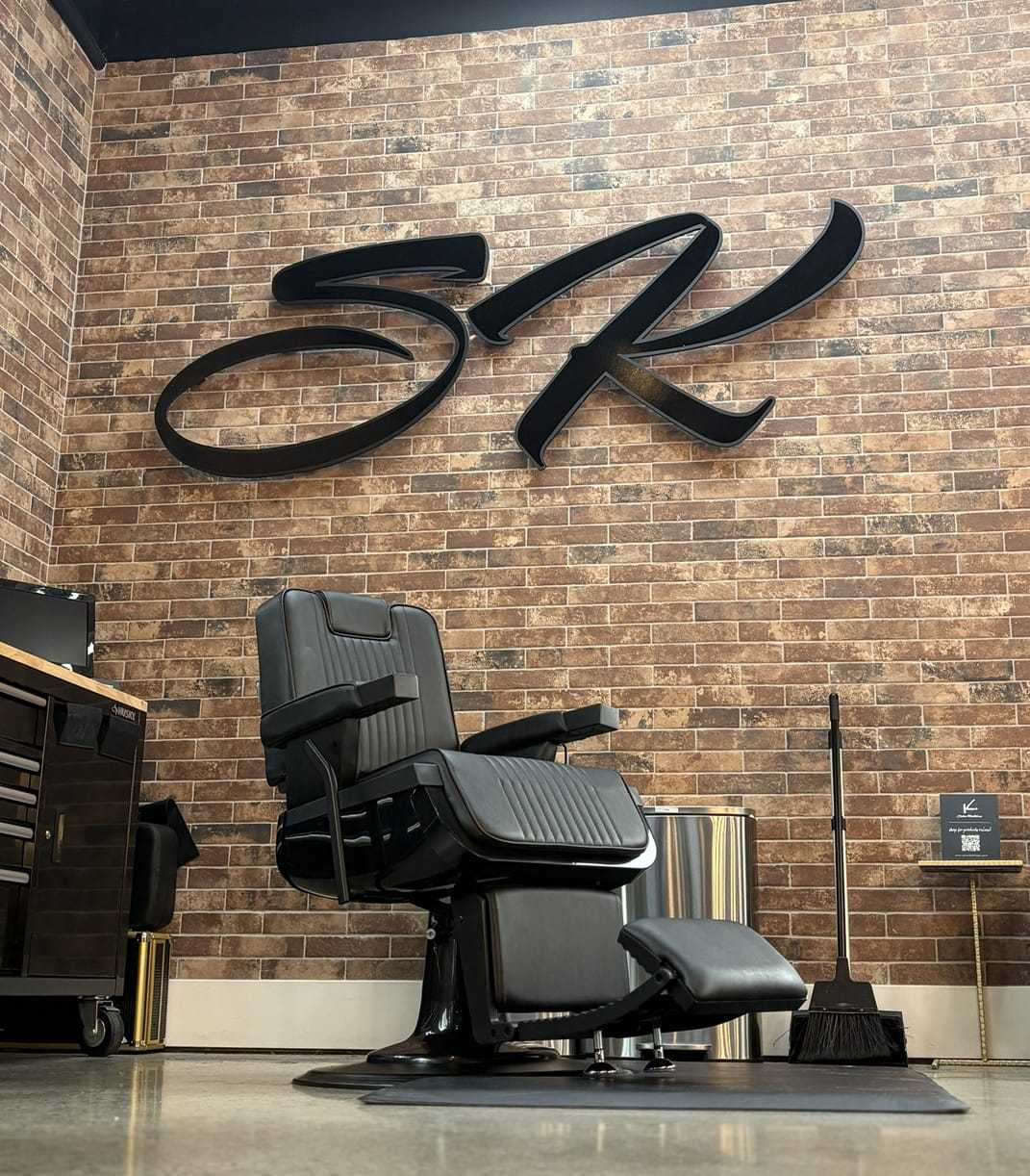 Barber chair in a stylish barber shop with brick wall and sleek decor.
